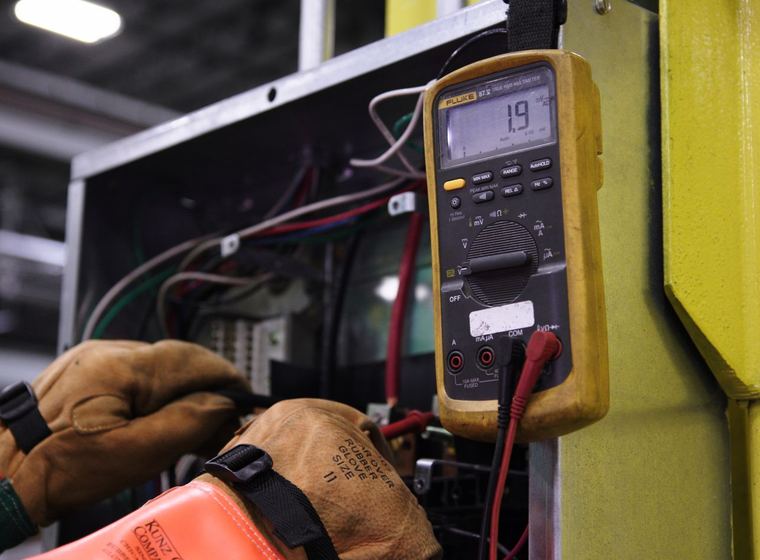 A multimeter reading voltage on a live control board
